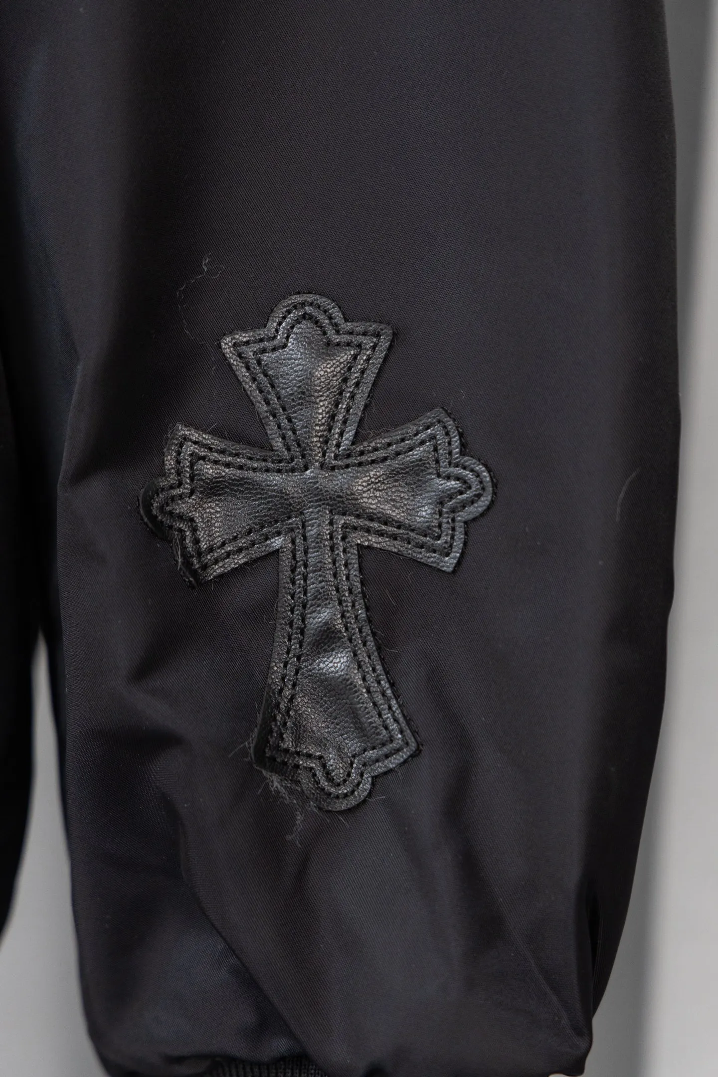 P410 Style No.: S045 This is a velvet baseball jacket from **Chrome Hearts**. It is a representative item of the brand that combines dark pioneer style with American street culture. It is also a trendy item that combines personality and warmth in autumn and winter. Design Highlights Iconic Elements: The brand’s classic cross leather embroidery is embellished throughout the body, paired with metallic hardware decorations (such as zipper pullers and hang tags). It combines Gothic religious symbols with heavy metal style, which is highly recognizable and is an intuitive embodiment of Crow Heart’s “dark luxury” tone.  Style and structure: It adopts the classic baseball uniform style, with a stand-up collar design and a two-way zipper, which is neat and stylish; the zipper pockets on the sleeves and the diagonal pockets on the body not only enhance the street feel, but are also practical.  Material splicing: The outer layer is made of high-density windproof fabric, and the inner layer is filled with velvet material, which has excellent thermal insulation performance; the threaded design of the collar and cuffs improves the overall crispness and wearing comfort. Craftsmanship and Quality: The cross is veneered using imported leather + hand-embroidered craftsmanship, with fine stitching and strong three-dimensional effect; the metal hardware has been distressed to give it a vintage and distressed texture, and the details reflect the brand's strict requirements for craftsmanship.  The velvet inner liner is evenly and fully filled, and the splicing process with the outer fabric is rigorous. It is not easy to deform after long-term wear, and has excellent warmth retention and durability. Style and Outfit This jacket is based on dark street style, and its black main tone is versatile and high-end. It can be paired with ripped jeans and Martin boots to create a cool street style in daily life; it can also be worn with a turtleneck sweater and a long coat on the outside. It can be layered to create layers, making it easily suitable for niche trendsetters, rock enthusiasts and other diverse style groups. It is an eye-catching item in the autumn and winter wardrobe that shows individuality. Size: s-XL Color: Black